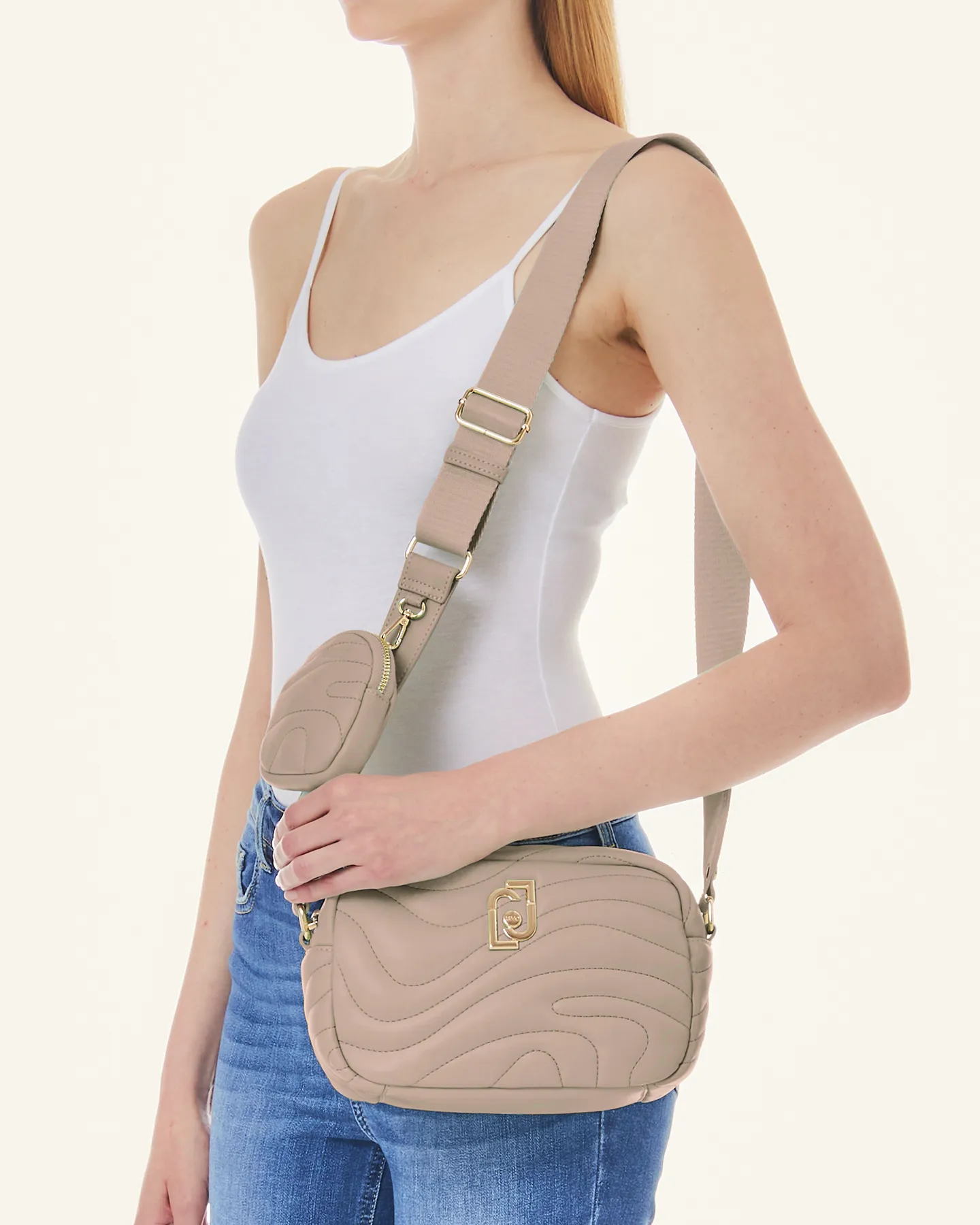 Cross bag cipria in similpelle trapuntata a onde con logo dorato e tracolla spessa in gros grain con charm portamonete
